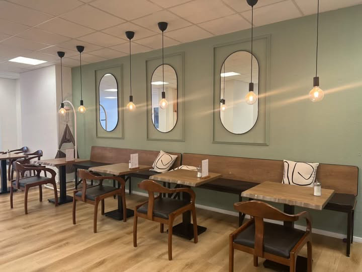 Café-Bereich mit Spiegelwand und warmen Pendelleuchten