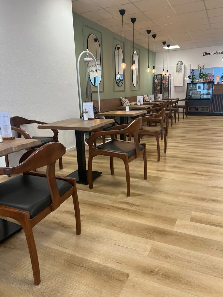 Sitzbereich mit Holztischen und Stühlen